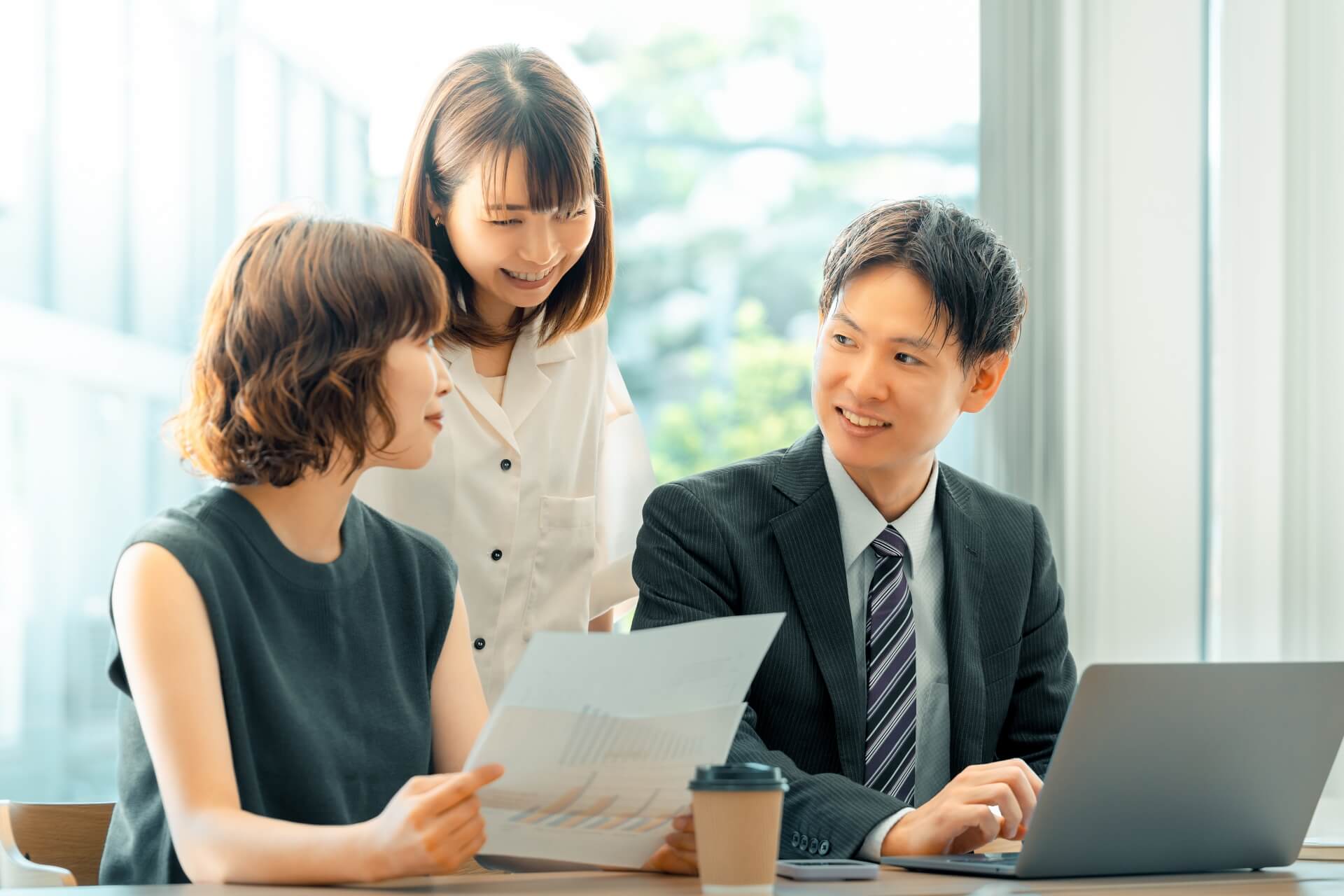 資料を囲んで談笑するビジネスマンたち